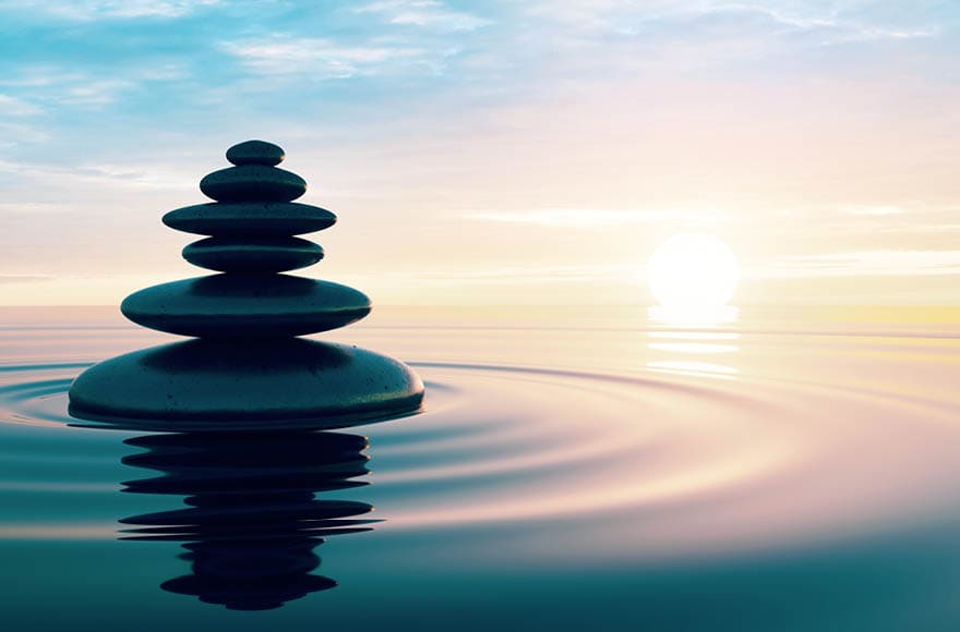 Stack of Stones in calm water with evening clouds