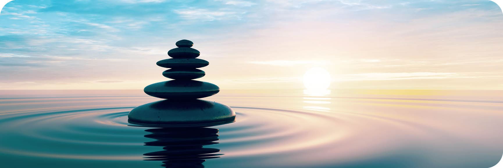 Stack of Stones in calm water with evening clouds