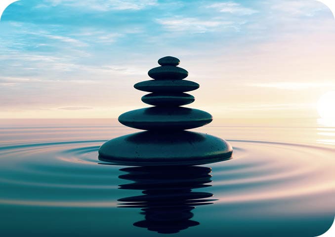 Stack of Stones in calm water with evening clouds