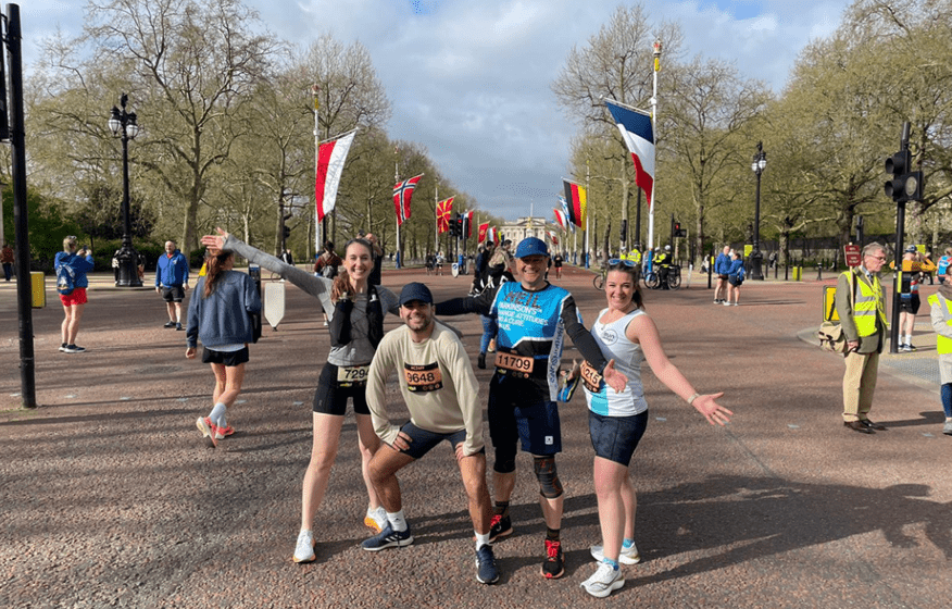 Four people are posing for a picture on a street. AI generated content